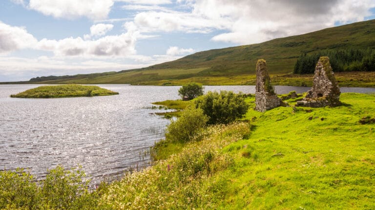 Eine Hausruine am Loch Finlaggan, im Hintergrund ist die Ratsinsel zu sehen.