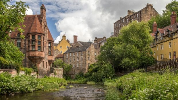 Das Dean Village liegt am Water of Leith. Hier sind alte Häuser aus Stein an einer malerischen Flussbiegung gelegen.