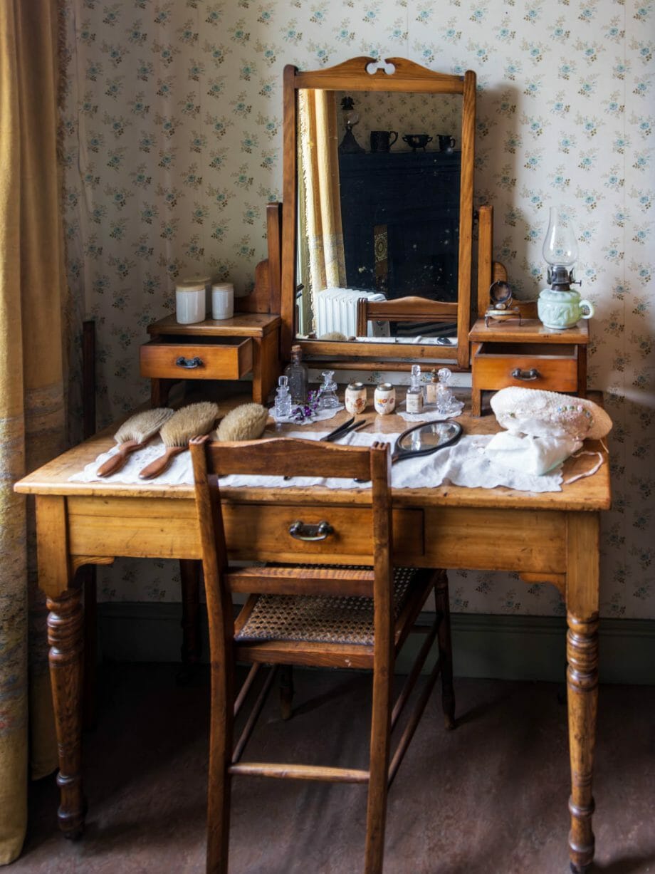 Ein Toilettentisch aus dem 19. Jahrhundert mit Bürsten und Kämmen darauf und einem Spiegel