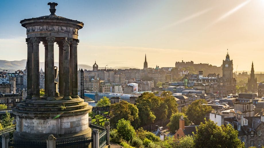 Blick vom Carlton Hill auf die Altstadt von Edinburgh. Links ist das runde Dugald Stewart Monument im Bild, rechts ist der Uhrenturm des Balmoral Hotels zu sehen. In der Ferne sitzt die Edinburgh castle auf dem Hügel.