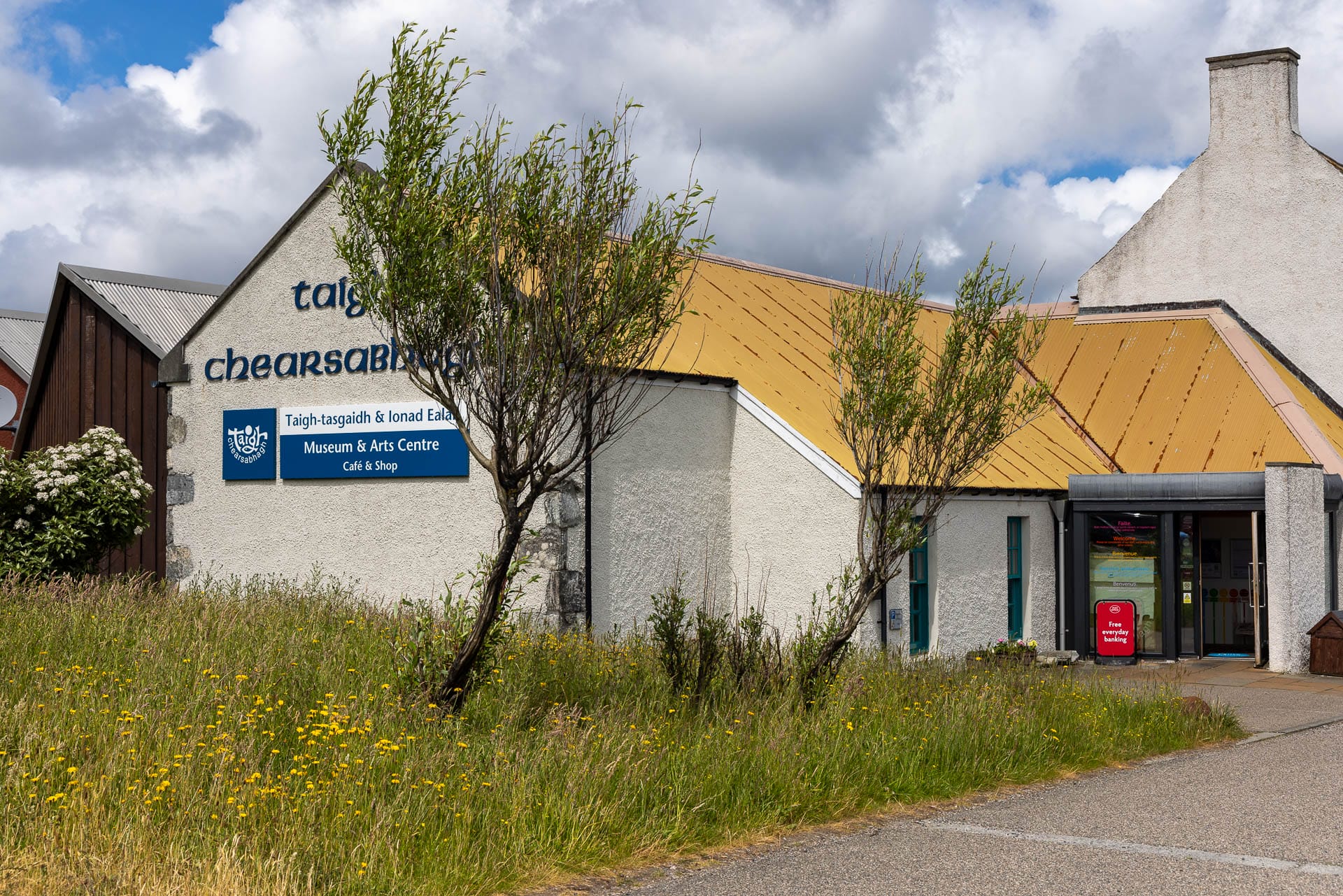 Ein helles, modernes Haus mit Giebeln. Es ist das Museum von Lochmaddy.