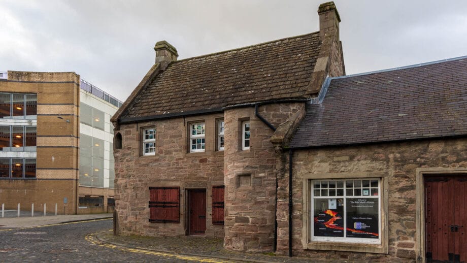 Ein altes Sandsteinhaus mit Butzenscheiben und einem runde Erker. Das ist das The Fair Maid's House in Perth.