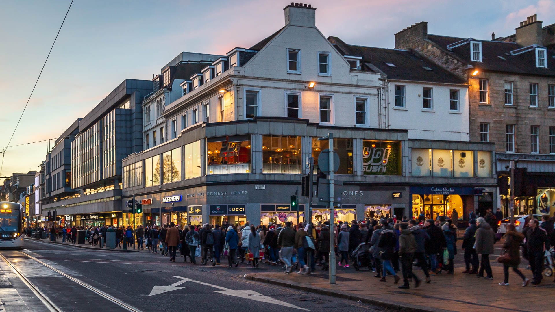 Menschenmengen laufen durch die Straße in Edinburgh während der Black-Friday-Wochen.