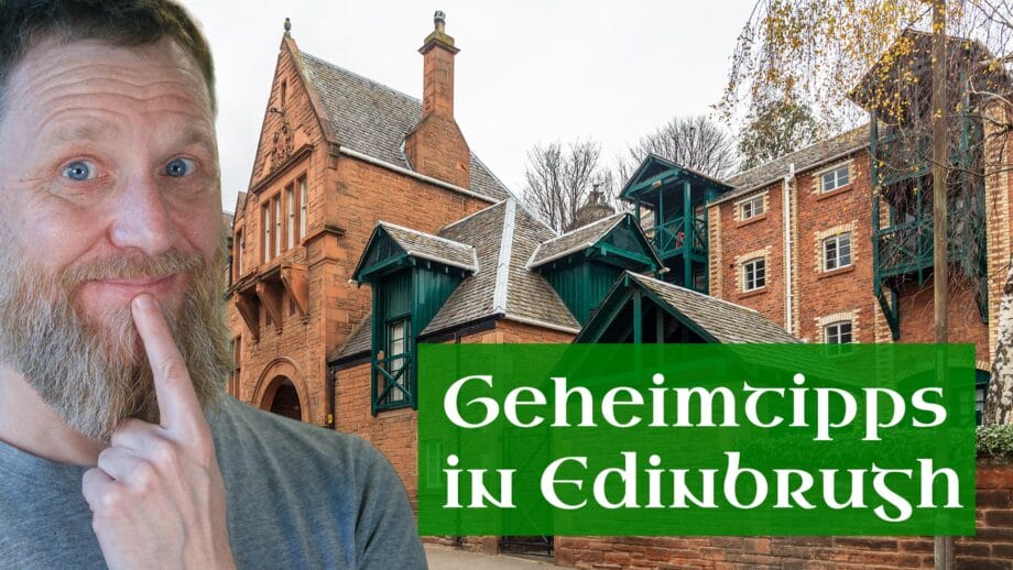 Ein Mann hält sich den Finger ans Kinn, dahinter ein Gebäude.
