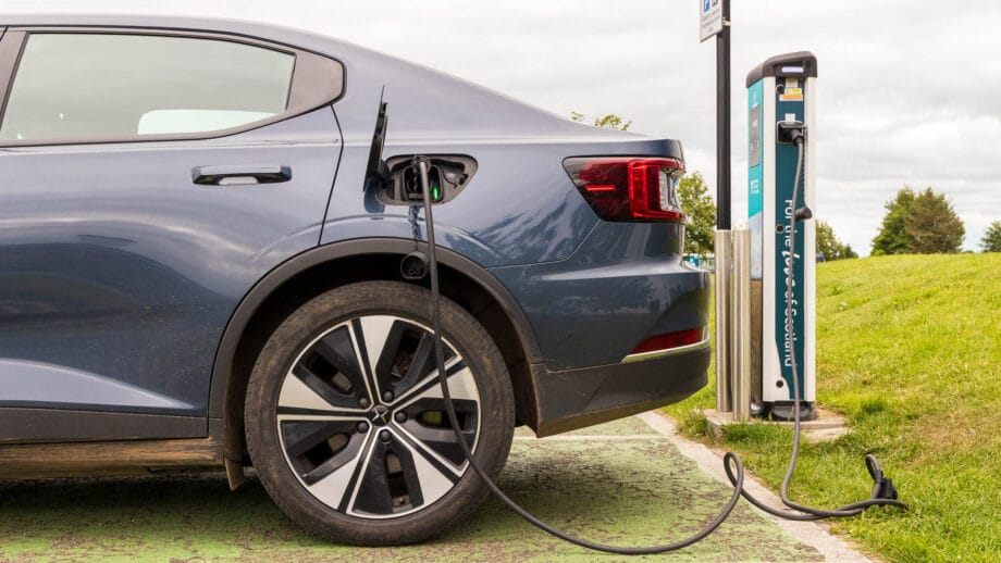 Das Heck eines Polestar 2 steht an einer Ladesäule für Elektroautos.