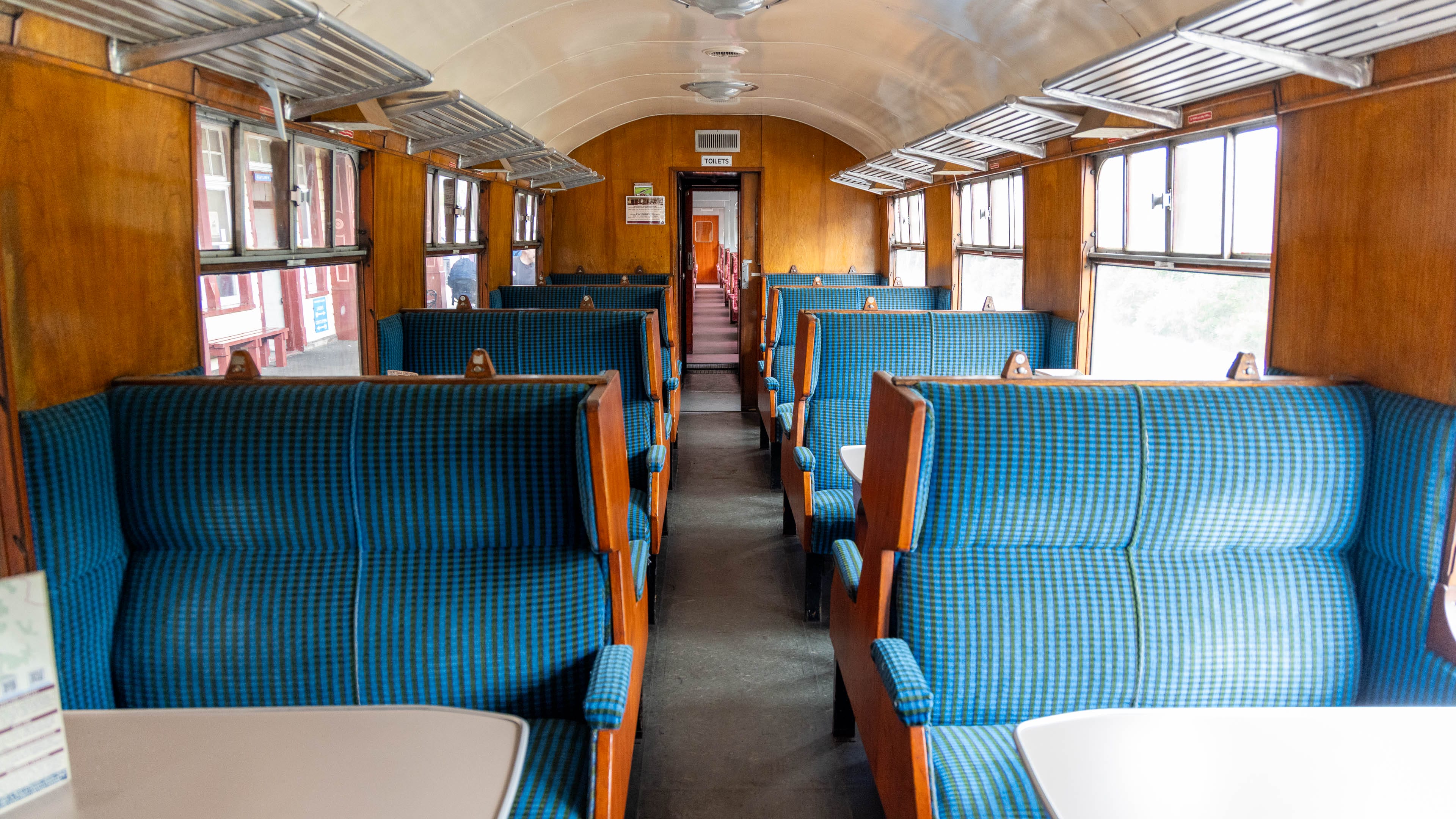 Sitzreihen mit blauem Stoff im Waggon der unteren Klasse.
