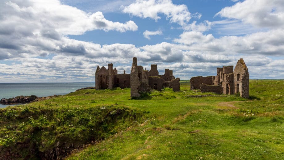 Die Slains Castle von Norden gesehen besteht nur noch aus einigen Mauern, die nahe einer Klippe zur Nordsee stehen.