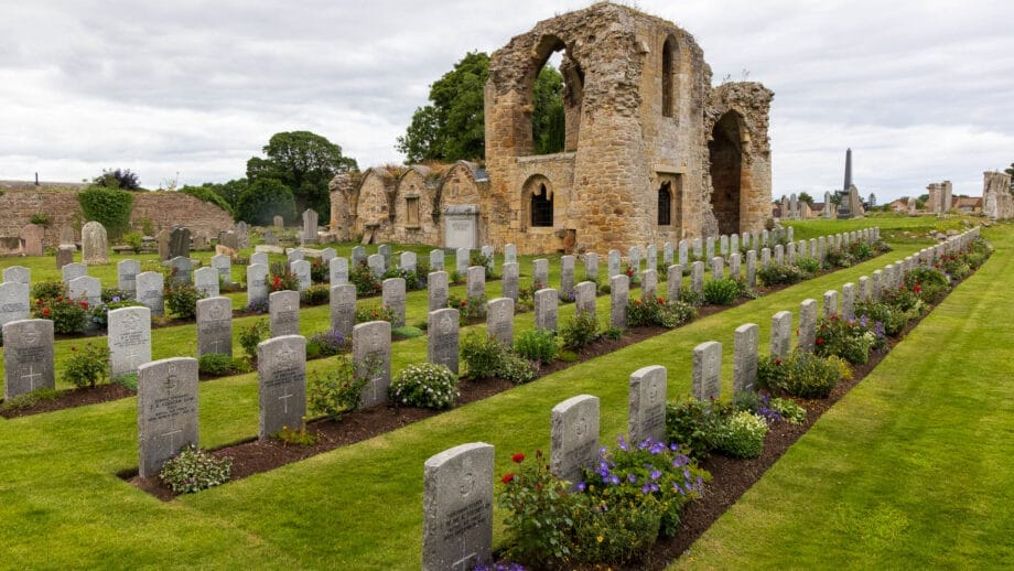 Die Ruinen von Kinloss Abbey stehen hinter einer Reihe Kriegsgräber