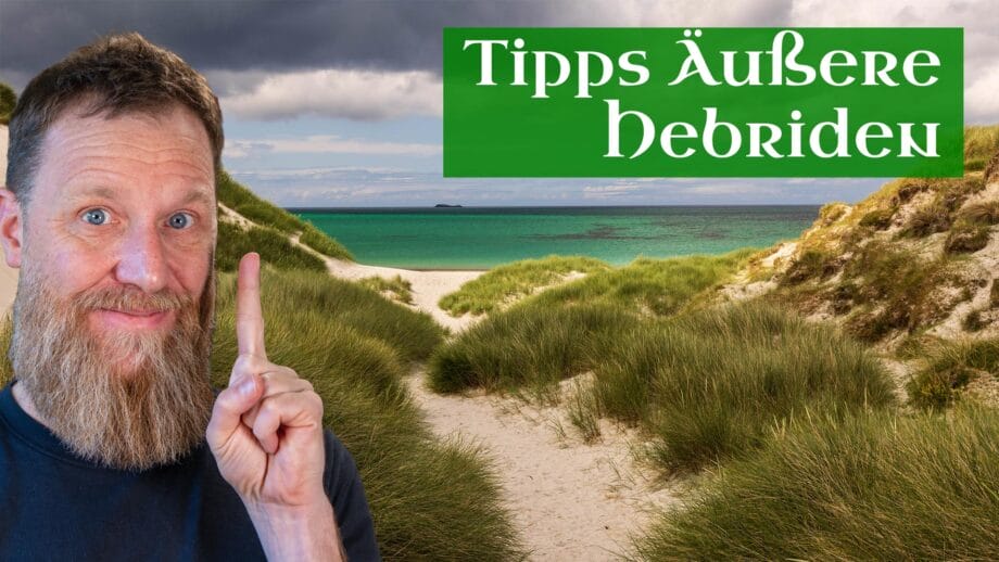 YT-Aeussere-Hebriden-Highlights-1 Ein Mann erhebt seinen Zeigefinger, weil er Tipps zu den Äußeren Hebriden anpreist, im Hintergrund ein traumhafter Strand.