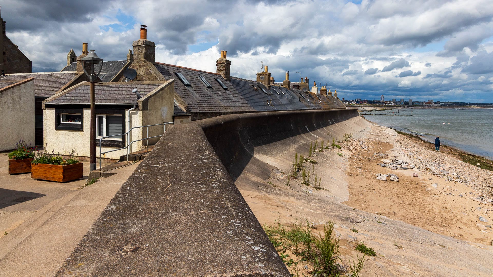 Eine Mauer schützt die Siedlung bei Sturm vor dem Meer.