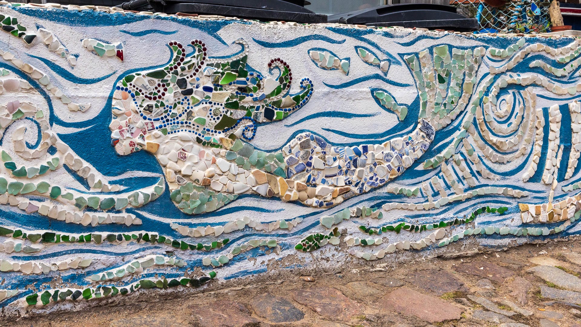 Mauer im Footdee, die eine Meerjungfrau aus Seeglas und Steinen zeigt