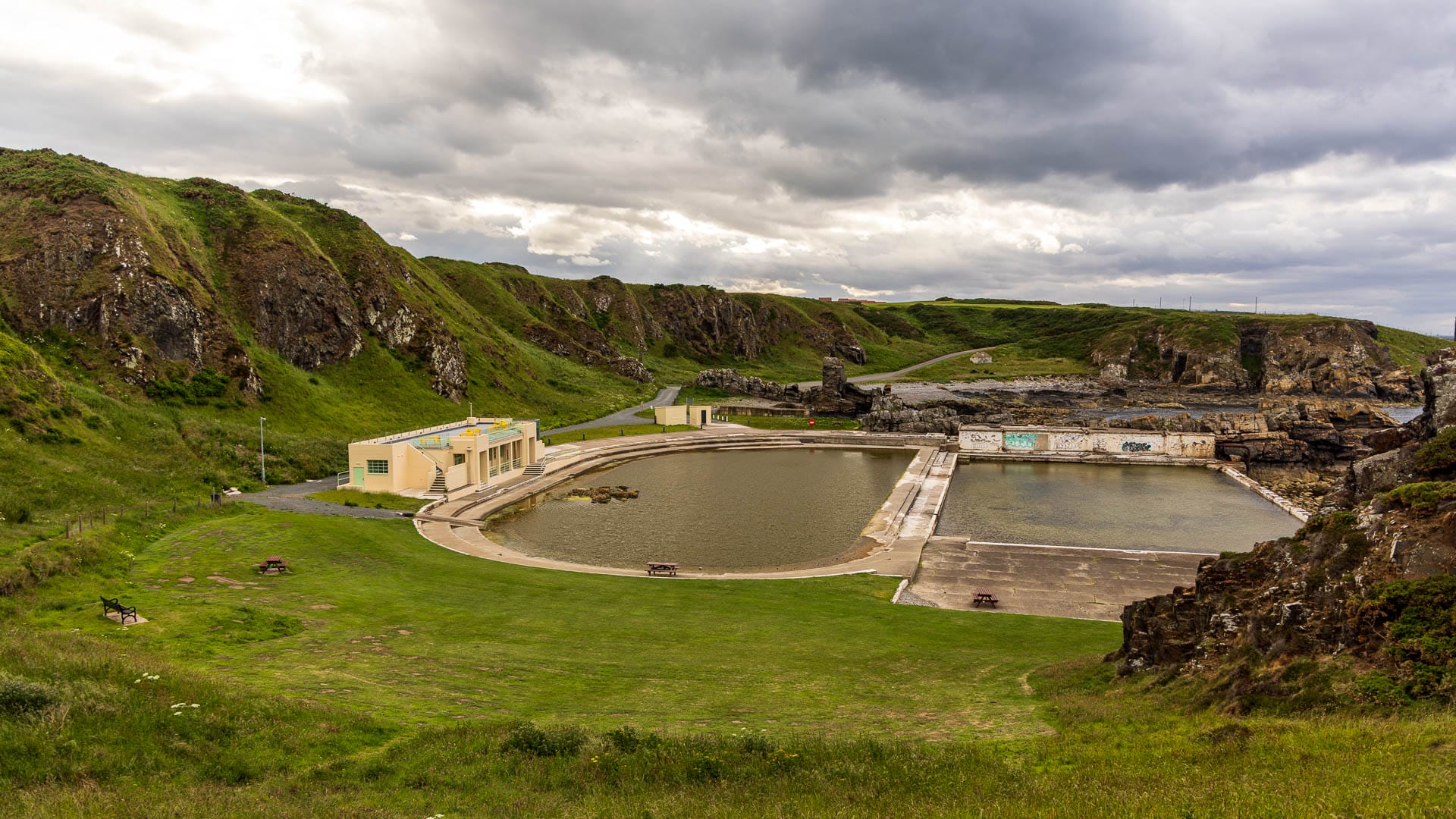 Blick von oben auf die Becken und das Teehaus des Tarlair Swimming Pools.
