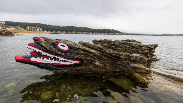 Bemalter Crocodile Rock am Strand von Millport