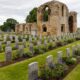 Die Ruinen von Kinloss Abbey stehen hinter einer Reihe Kriegsgräber